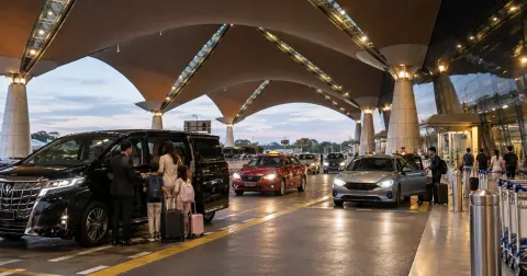 Private airport transfer vehicle outside a modern airport terminal in Malaysia
